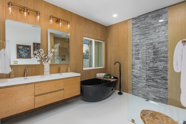 bathroom with a sink, walk in shower, double vanity, and a soaking tub