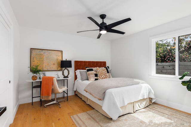 bedroom featuring light wood-style flooring, a ceiling fan, and baseboards