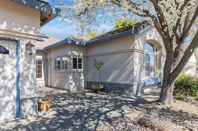 view of side of home with a patio area and stucco siding