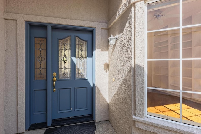 view of exterior entry with stucco siding