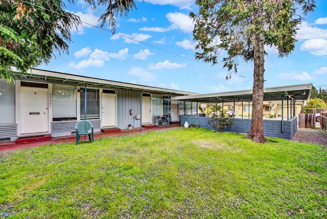 rear view of property with a lawn and board and batten siding