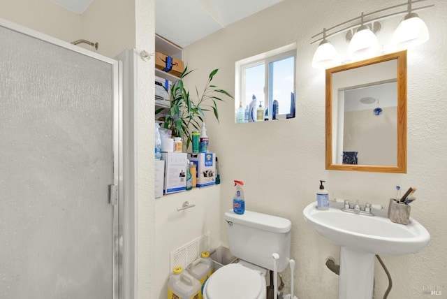 bathroom featuring toilet and a stall shower