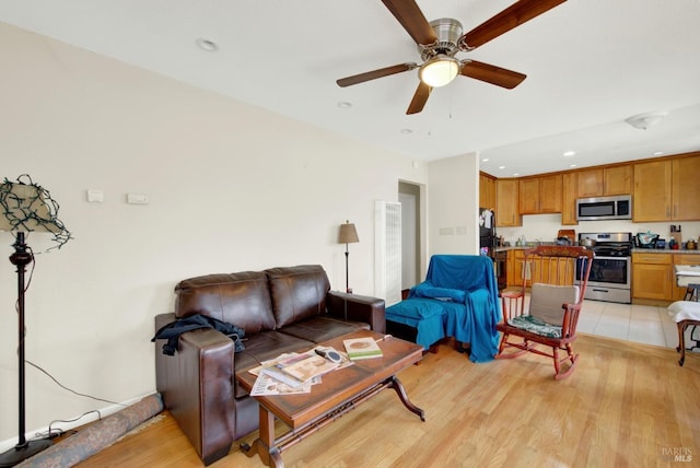 living area with recessed lighting, light wood-style floors, and a ceiling fan