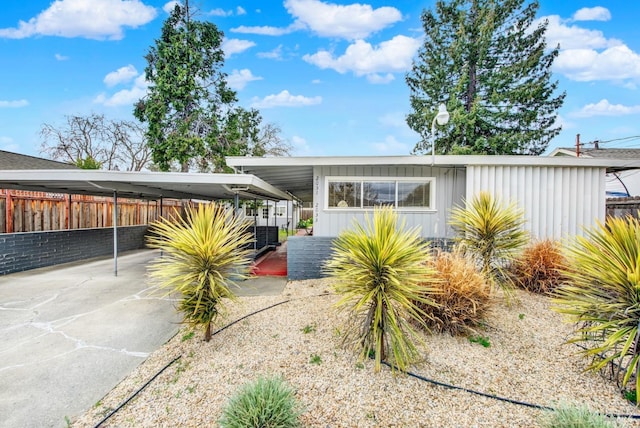 view of front of property with a carport and fence