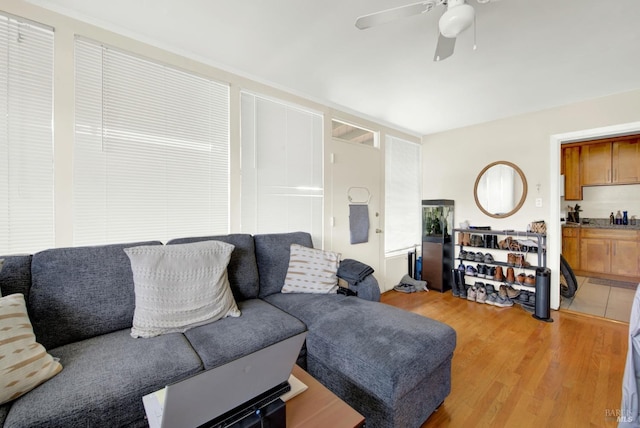 living area with light wood-style flooring and a ceiling fan