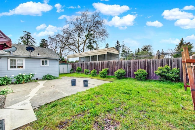 view of yard with a patio area, a storage shed, an outbuilding, and fence