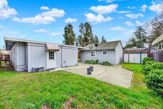 rear view of property featuring a yard, board and batten siding, a patio, and fence