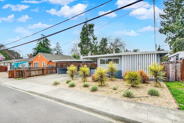 mid-century home featuring board and batten siding, driveway, and fence