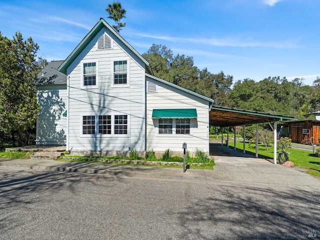 view of side of property featuring a carport and driveway