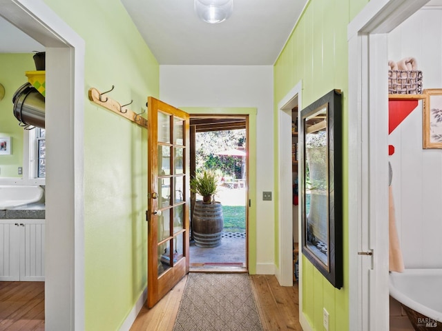 doorway to outside with baseboards and wood finished floors