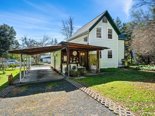 view of front of house with a carport, gravel driveway, and a front lawn