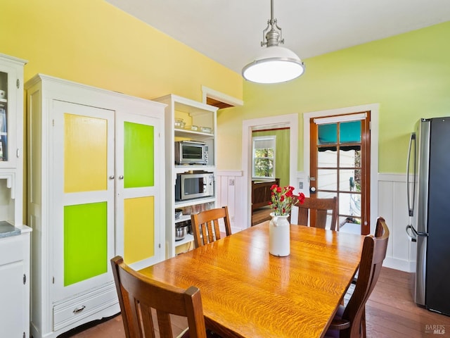 dining room featuring dark wood finished floors and wainscoting