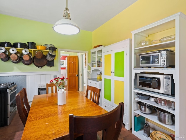 dining space featuring a wainscoted wall and heating unit