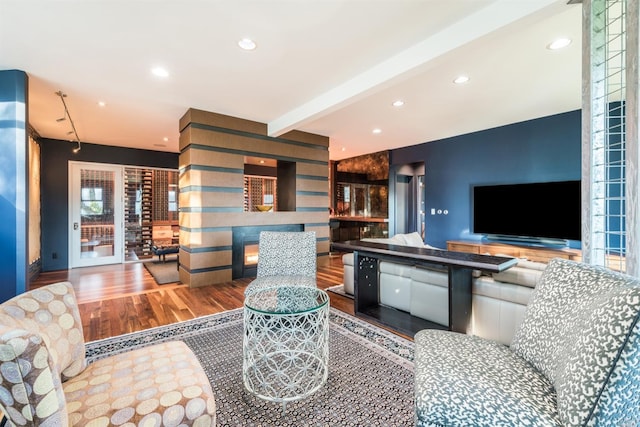 living area featuring recessed lighting, beam ceiling, and wood finished floors