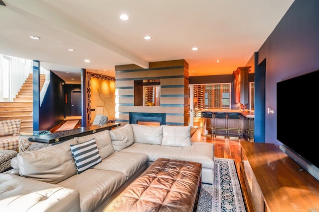 living area with stairway, wood finished floors, beamed ceiling, and recessed lighting