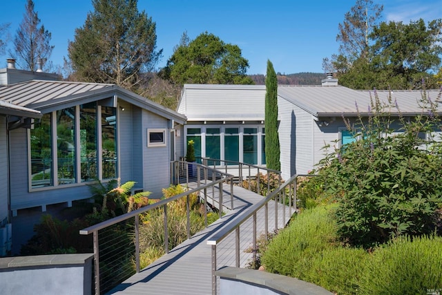 view of front of house with metal roof and a chimney