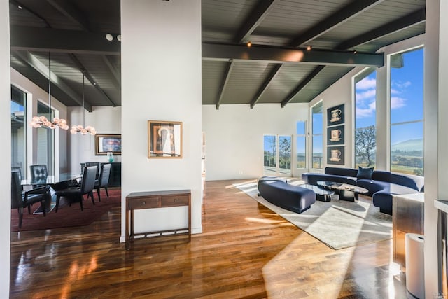 living room featuring beamed ceiling, wood finished floors, high vaulted ceiling, and a chandelier