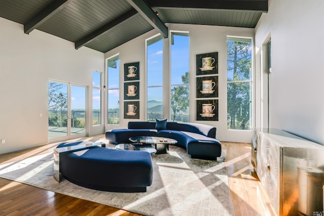 living area with wood ceiling, beamed ceiling, wood finished floors, and high vaulted ceiling