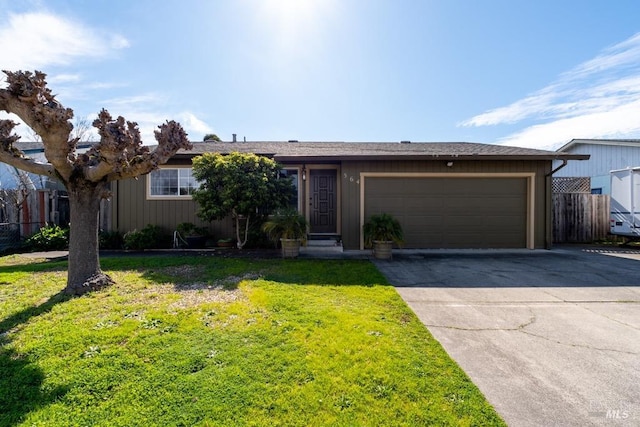 view of front of home with concrete driveway, a garage, fence, and a front lawn