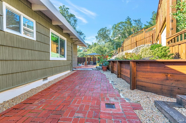 view of patio with outdoor dining area, a gazebo, and a fenced backyard