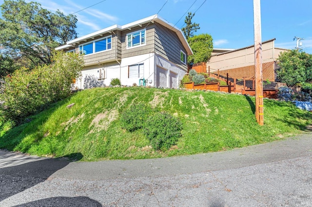 view of property exterior with mansard roof and a garage