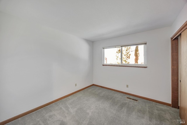 unfurnished bedroom with visible vents, carpet flooring, baseboards, and a closet