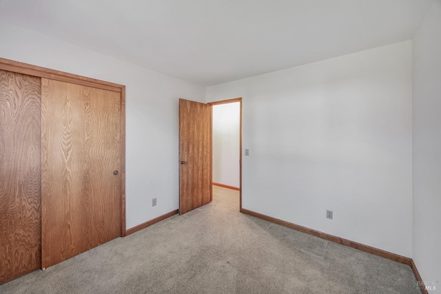 unfurnished bedroom with a closet, baseboards, and carpet