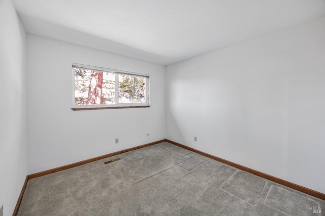 empty room featuring visible vents, baseboards, and carpet floors