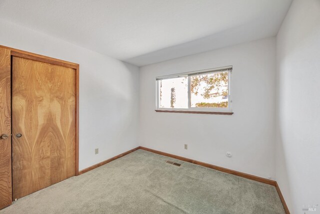 unfurnished bedroom with a closet, baseboards, visible vents, and carpet floors