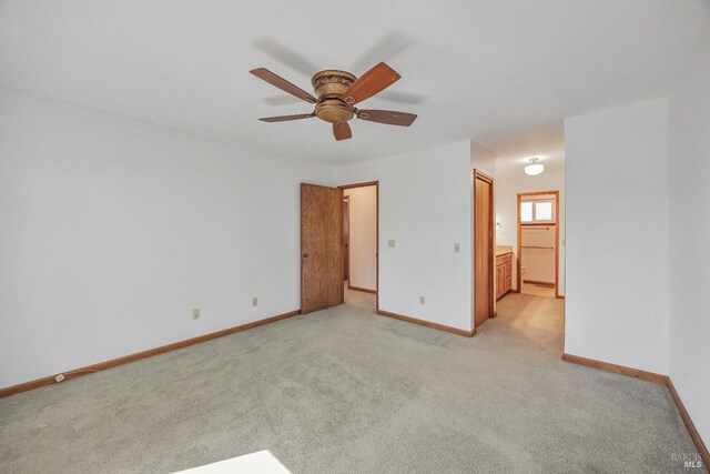 empty room with light colored carpet, baseboards, and ceiling fan