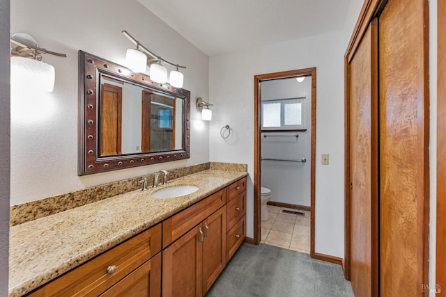 bathroom with vanity, visible vents, baseboards, tile patterned floors, and toilet