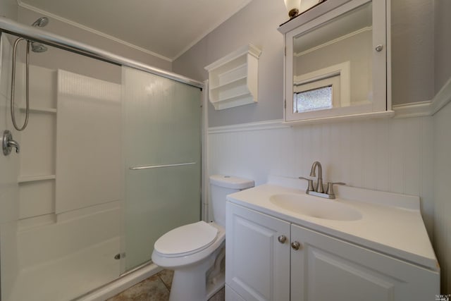 bathroom featuring a shower stall, tile patterned floors, toilet, vanity, and wainscoting