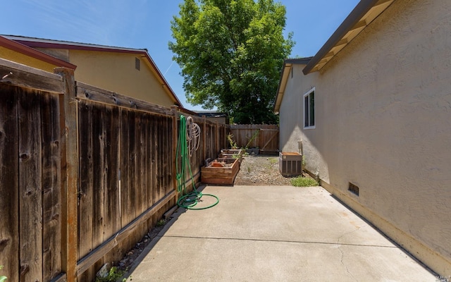 view of patio featuring a garden, central AC, and fence