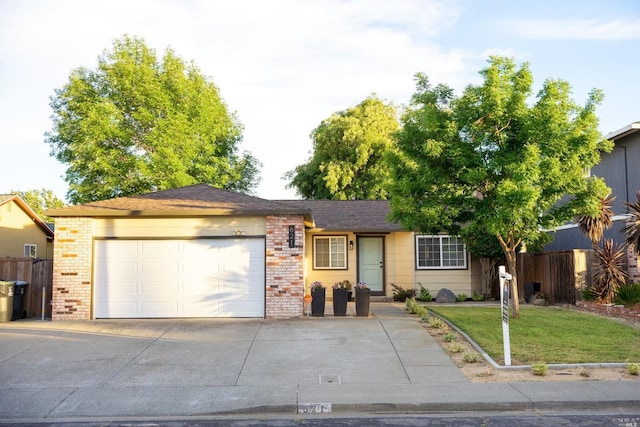 ranch-style home featuring concrete driveway, brick siding, fence, and a garage