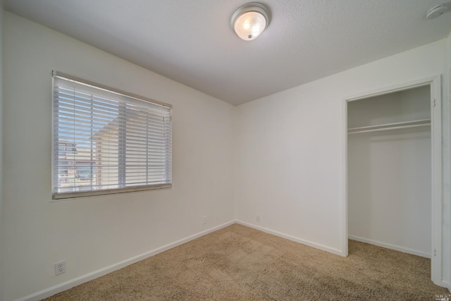 unfurnished bedroom featuring a closet, baseboards, and carpet floors