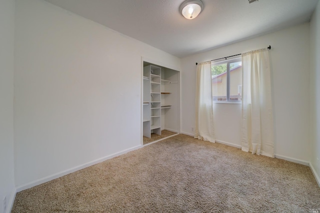 unfurnished bedroom featuring a closet, baseboards, and carpet flooring