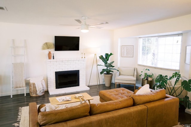 living area featuring visible vents, a brick fireplace, a ceiling fan, and wood finished floors