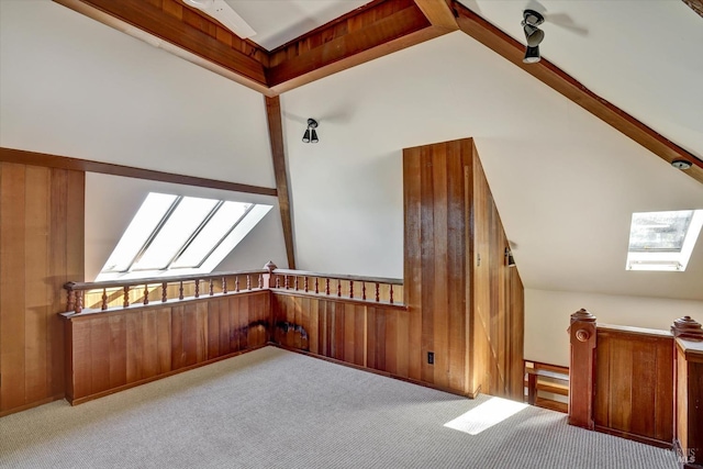 bonus room featuring vaulted ceiling with skylight, wooden walls, and carpet floors