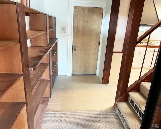 hall featuring tile patterned flooring and stairway