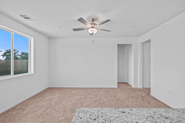 spare room featuring visible vents, carpet flooring, baseboards, and ceiling fan