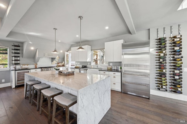 3292 Holland Dr, Santa Rosa, CA 95404 - kitchen featuring dark wood-style floors, a kitchen island, beverage cooler, and white cabinetry