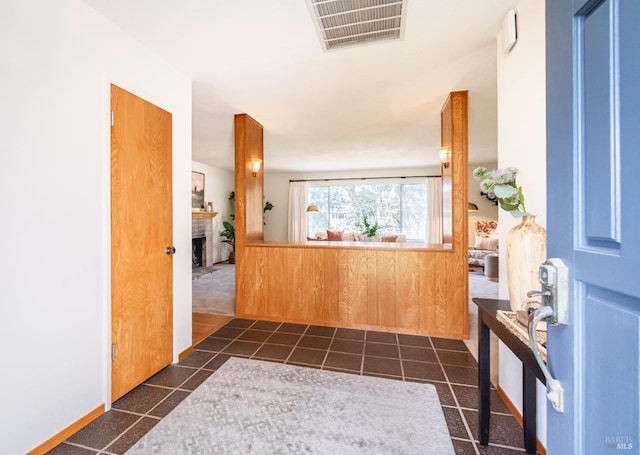 entrance foyer featuring dark tile patterned floors, visible vents, and a fireplace