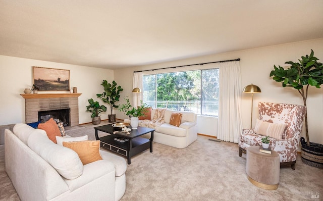 carpeted living area featuring a brick fireplace and visible vents