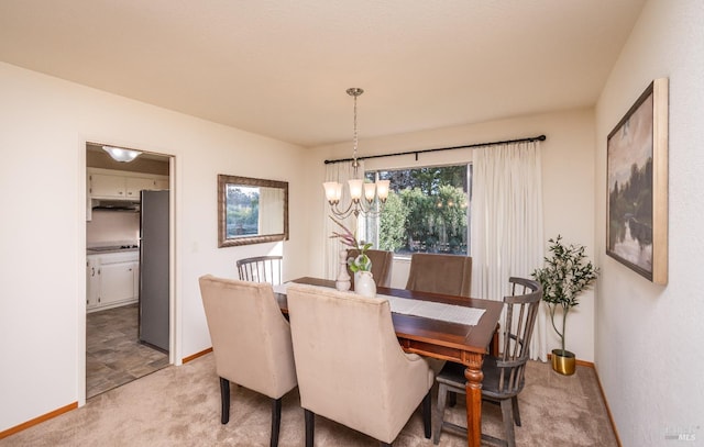 dining room with baseboards, light colored carpet, and an inviting chandelier