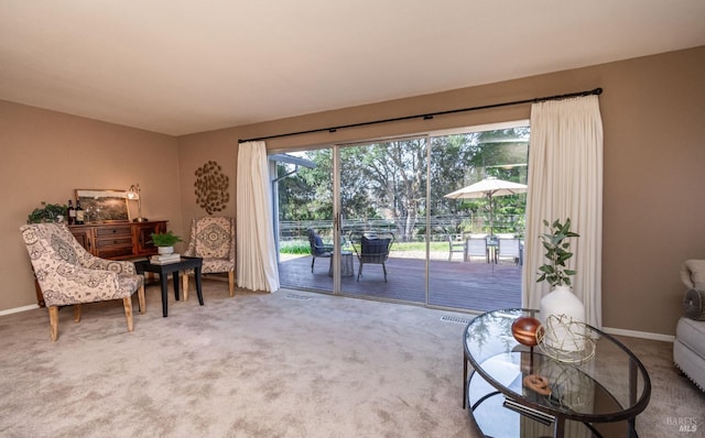 living area featuring visible vents, carpet, and baseboards