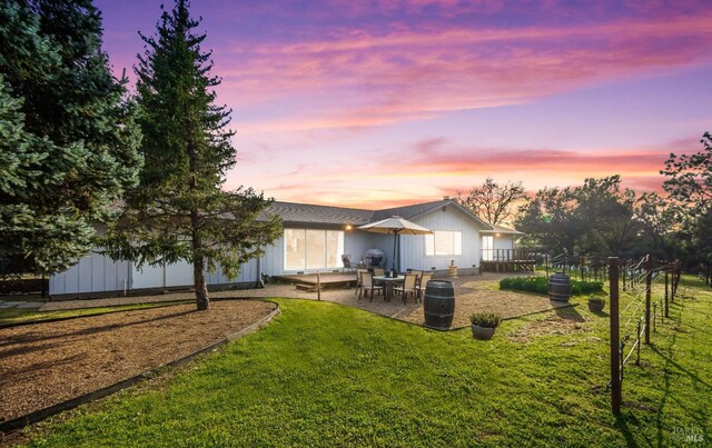 back of property featuring fence, a patio, and a yard