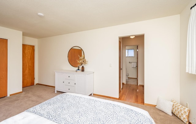 bedroom with baseboards and light carpet