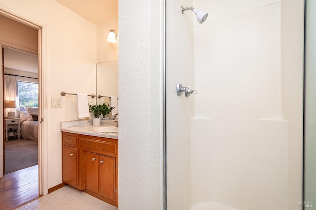 ensuite bathroom with vanity, ensuite bath, and a stall shower