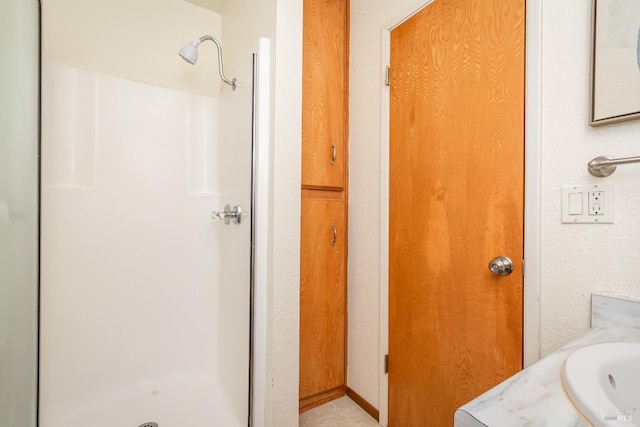 full bath with a sink and a shower stall