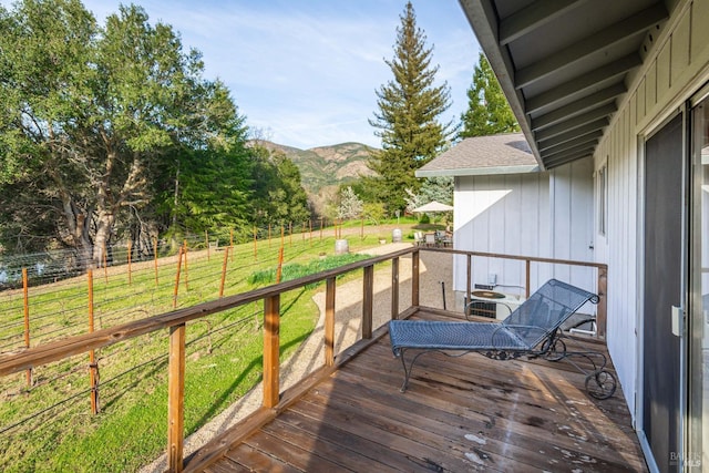 wooden terrace with central AC unit, a mountain view, and fence